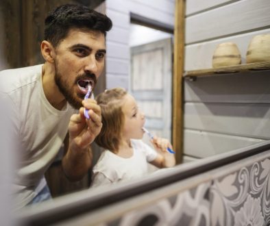 father and daughter brushing teeth